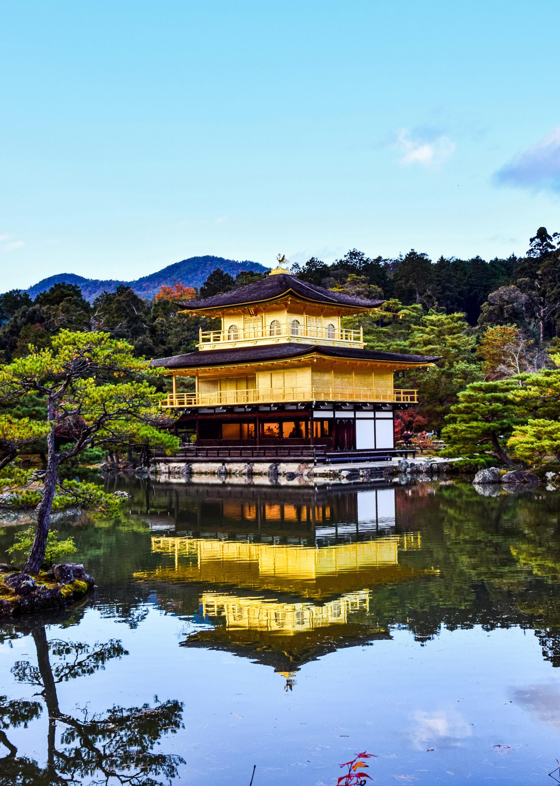 Serene view of Kinkaku-ji reflecting in a tranquil lake in Kyoto, Japan.